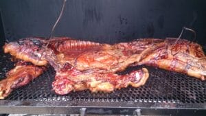 Whole pig roasting on the grill, a grand spectacle of outdoor cooking
